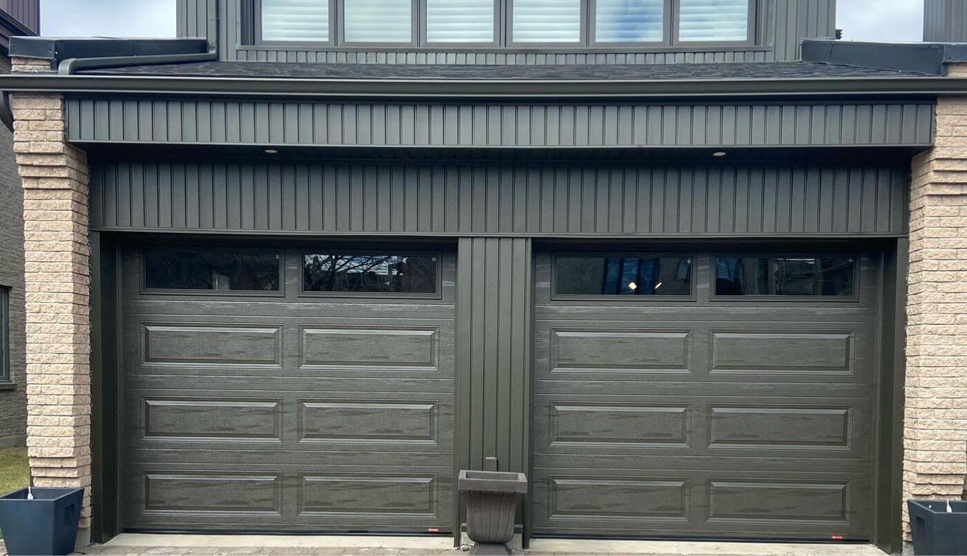Deux portes de garage flanquées d'un mur en briques et d'une allée en briques, offrant une esthétique élégante et robuste.