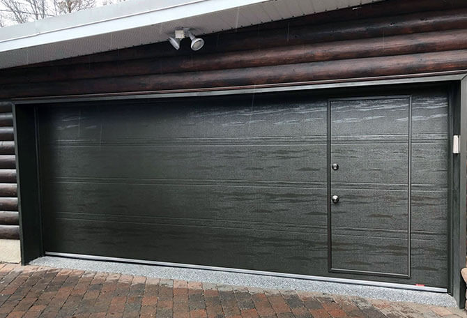 Porte de garage noire avec porte de passage intégrée, installée par Pro-Fix Bélair à Montréal