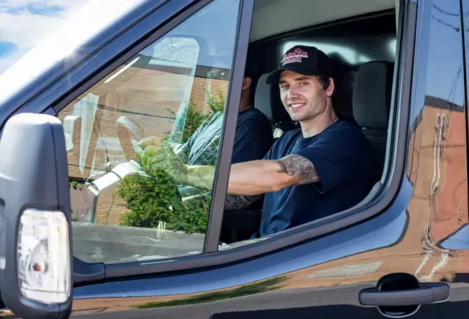 Installateur dans son camion souriant
